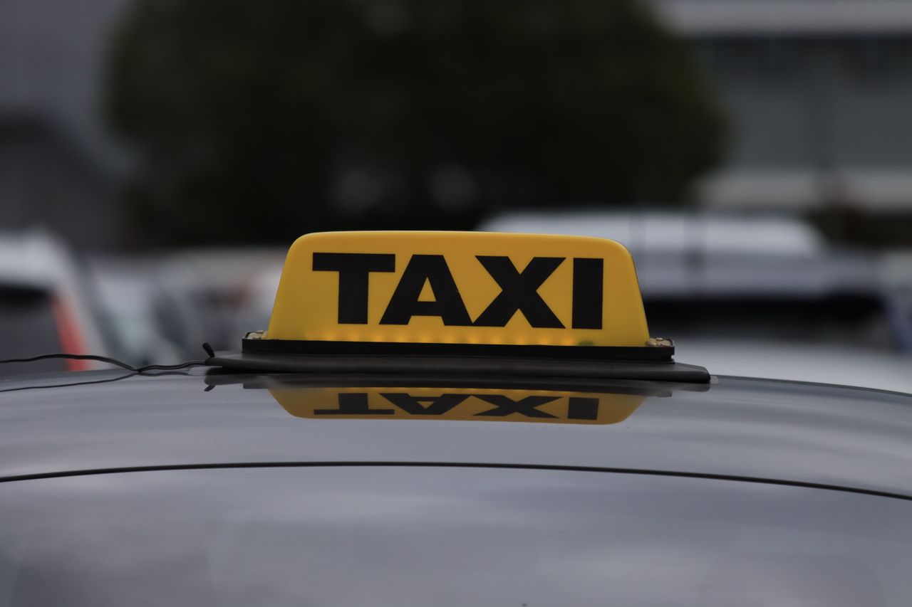 The Art of Drawing Readers In: Your attractive post title goes here Yellow taxi sign on a car roof in a city parking area during daylight.