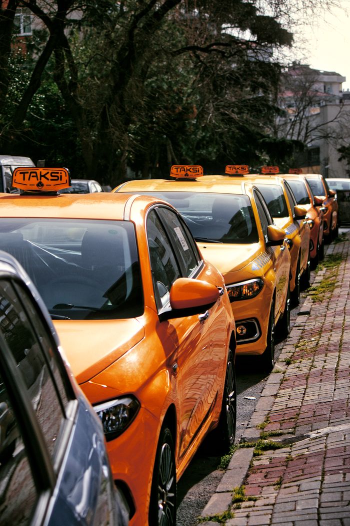 Services Close-up of multiple yellow taxis on a cobblestone street, hinting at lively urban transportation.